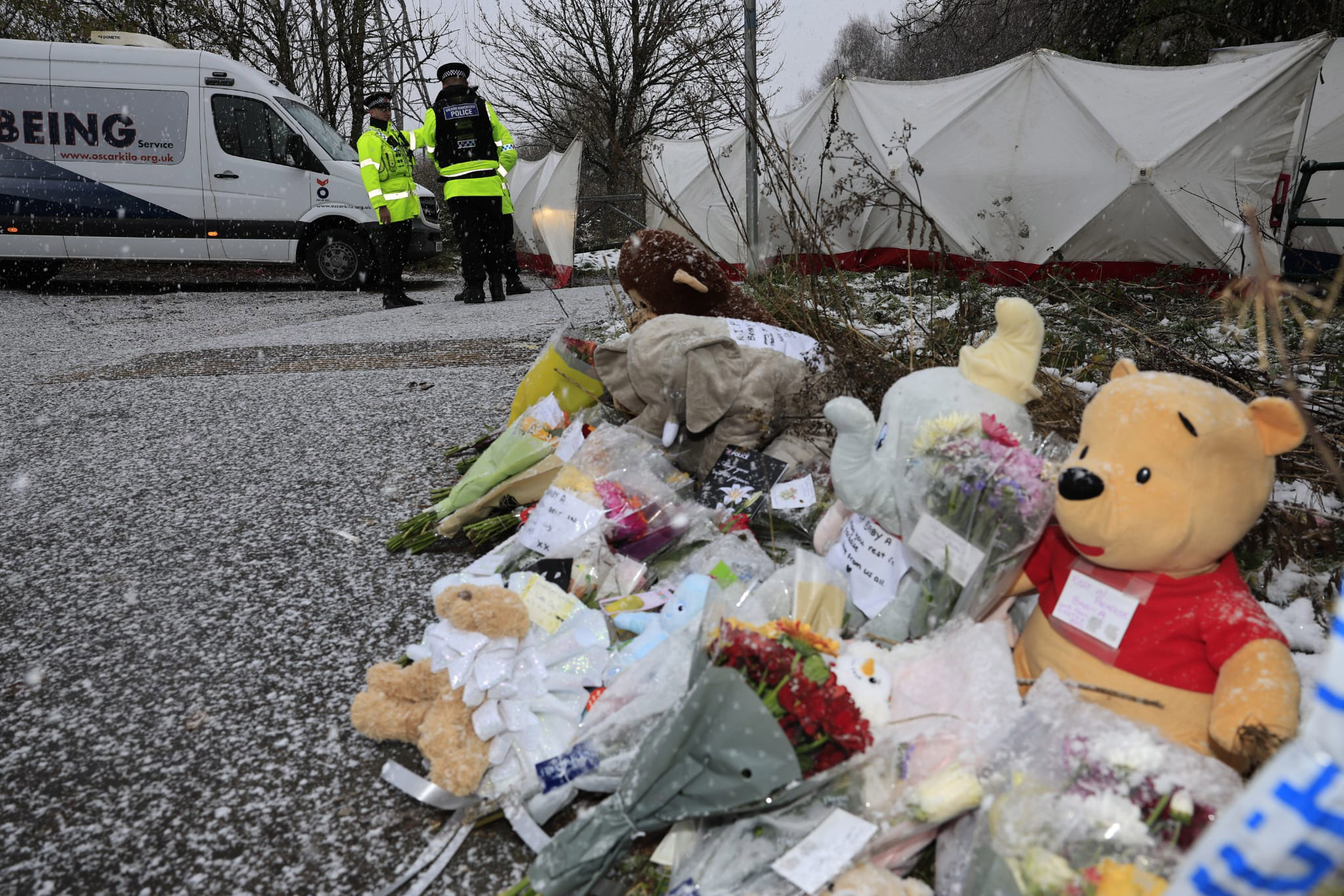 Members of the public leave flowers, soft toys and cards outside the scene in Salford.